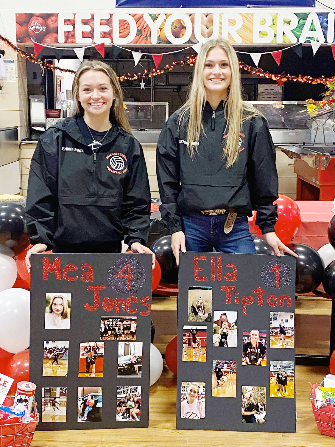 BELLE TIGER volleyball seniors (from left) Mea Jones and Ella Tipton stand with their photo boards after celebrating their senior-night victory over St. James last Thursday. Jones was sick and unable to play in the match.